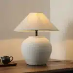Wabi sabi table lamp with textured ceramic base and linen shade in a cozy living room