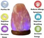 Salt lamp with color changing on wooden base glowing in warm light