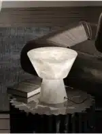 Elegant marble table lamp with soft glow on bedside table in bedroom