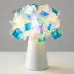 Modern table lamp with PVC flower design in a cozy bedroom setting