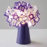 Modern table lamp with PVC flower design in a cozy bedroom setting