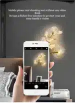 Luxury gold leaf sconce with modern ginkgo design illuminating a living room wall