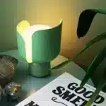 Rotating petal desk lamp with adjustable petals in pastel colors on a bedside table