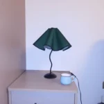 Elegant handmade petal lampshade casting a warm glow in a cozy bedroom