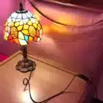Vintage table lamp with handmade colored glass shade casting warm ambient light