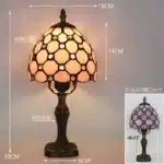 Tiffany table lamp with colorful stained glass shade casting warm glow on nightstand