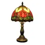 Tiffany table lamp with tulip stained glass shade, rustic bronze base, glowing warmly