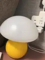 Mushroom table lamp with cream ceramic shade on bedside table