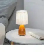 Milkshake bedside table lamp with warm LED light on a nightstand in a cozy bedroom