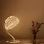 3D LED table lamp with wooden base and acrylic art glowing in a cozy room