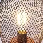 Battery table lamp with metal cage and warm LED glow on a wooden table