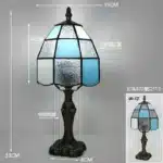 Tiffany table lamp with colorful stained glass shade casting warm glow on nightstand