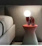 Modern glass table lamp with spherical shade on a wooden nightstand in a cozy bedroom