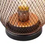Battery table lamp with metal cage and warm LED glow on a wooden table