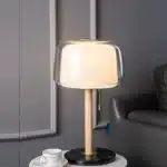 Modern bedside lamp with cream glass shade on a nightstand