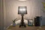 White ghost table lamp with transparent baroque design on a bedside table in a modern bedroom