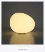 Modern table lamp with warm glow on bedside table