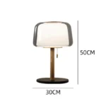 Modern bedside lamp with cream glass shade on a nightstand