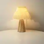 Handmade rattan bedside lamp with pleated shade on vintage nightstand