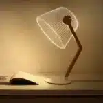 3D LED table lamp with wooden base and acrylic art glowing in a cozy room