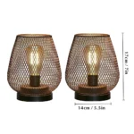 Battery table lamp with metal cage and warm LED glow on a wooden table