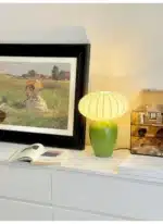 Vintage table lamp with retro ceramic base and silk shade on bedside table in cozy bedroom