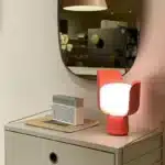 Rotating petal desk lamp with adjustable petals in pastel colors on a bedside table