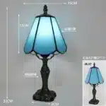 Tiffany table lamp with colorful stained glass shade casting warm glow on nightstand