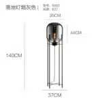 Modern floor lamp with iron frame and glass shade in a cozy living room