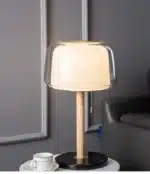 Modern bedside lamp with cream glass shade on a nightstand