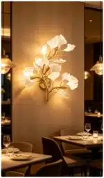 Luxury gold leaf sconce with modern ginkgo design illuminating a living room wall