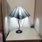 Elegant handmade petal lampshade casting a warm glow in a cozy bedroom