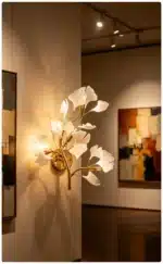 Luxury gold leaf sconce with modern ginkgo design illuminating a living room wall