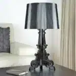 White ghost table lamp with transparent baroque design on a bedside table in a modern bedroom