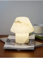 Elegant marble table lamp with soft glow on bedside table in bedroom
