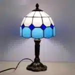 Vintage table lamp with handmade colored glass shade casting warm ambient light