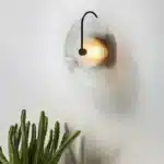Modern wall lamp with minimalist Nordic design illuminating a cozy bedroom bedside
