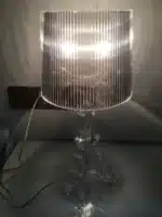 Modern acrylic table lamp glowing softly on a bedside table in a contemporary bedroom