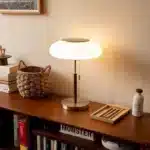 White glass table lamp with vintage design on a wooden desk in a cozy bedroom