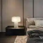Elegant marble table lamp with soft glow on bedside table in bedroom