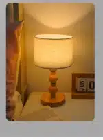 Vintage table lamp with fabric shade and solid wood base on bedside table