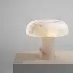 Elegant marble table lamp with soft glow on bedside table in bedroom