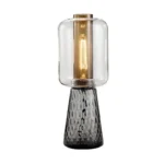Modern table lamp with glass shade on bedside table