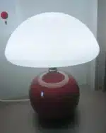 Mushroom table lamp with cream ceramic shade on bedside table