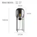 Modern floor lamp with iron frame and glass shade in a cozy living room