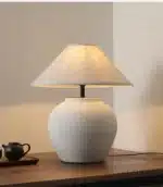 Wabi sabi table lamp with textured ceramic base and linen shade in a cozy living room