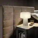 Elegant marble table lamp with soft glow on bedside table in bedroom