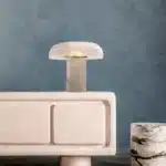 Elegant marble table lamp with soft glow on bedside table in bedroom