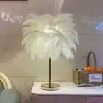 Ostrich feather table lamp glowing warmly on a bedside table in a cozy bedroom