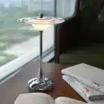 Goldoma rechargeable table lamp with flying saucer shape and warm glow on a bedside table